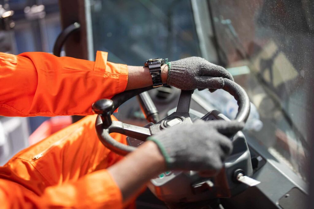 A construction worker driving a piece of machinery