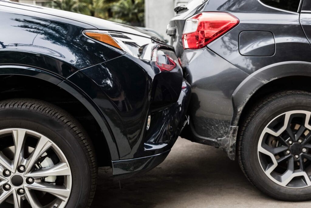 Black car crashed into the back of a gray car. 