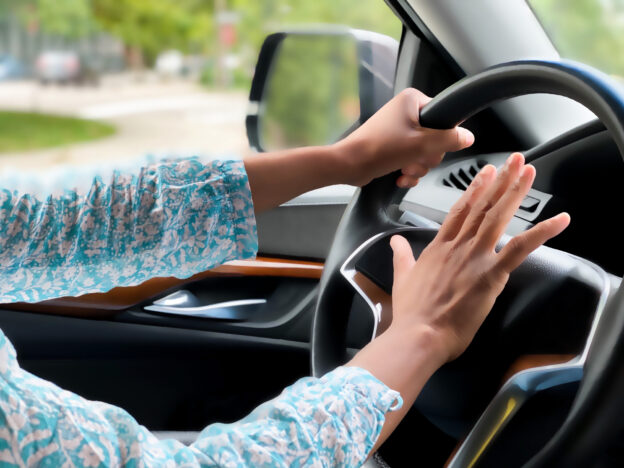 Hand pressing on the steering wheel horn