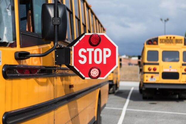 A stop sign attached to the side of a school bus