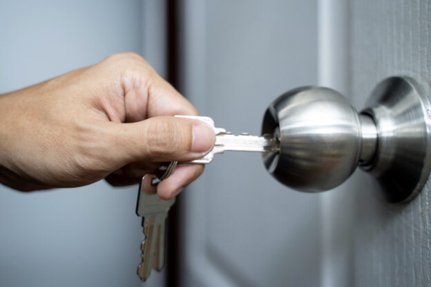 A person entering a key into a door