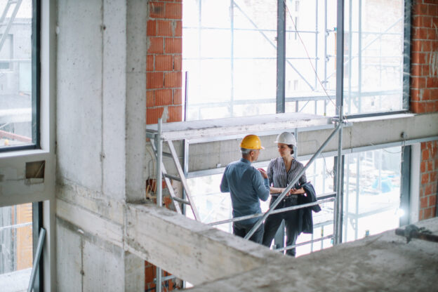 Colleagues discussing work at the construction site