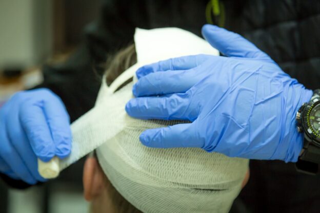 Man Getting His Head Wrapped In Bandages After Concussion