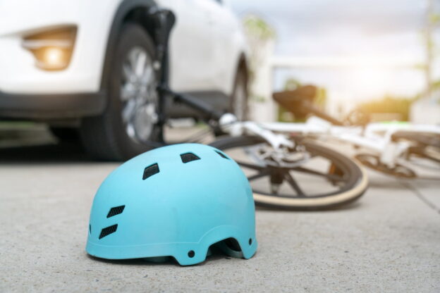 Blue helmet with a bicycle and a white car in the background