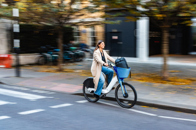 Young adult woman commuting on an electric bicycle, embracing a sustainable and active lifestyle